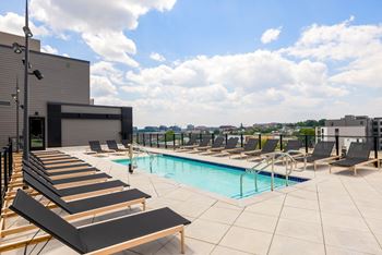 a swimming pool on the roof of a building with lounge chairs at The Chase at Bryant Street, District of Columbia